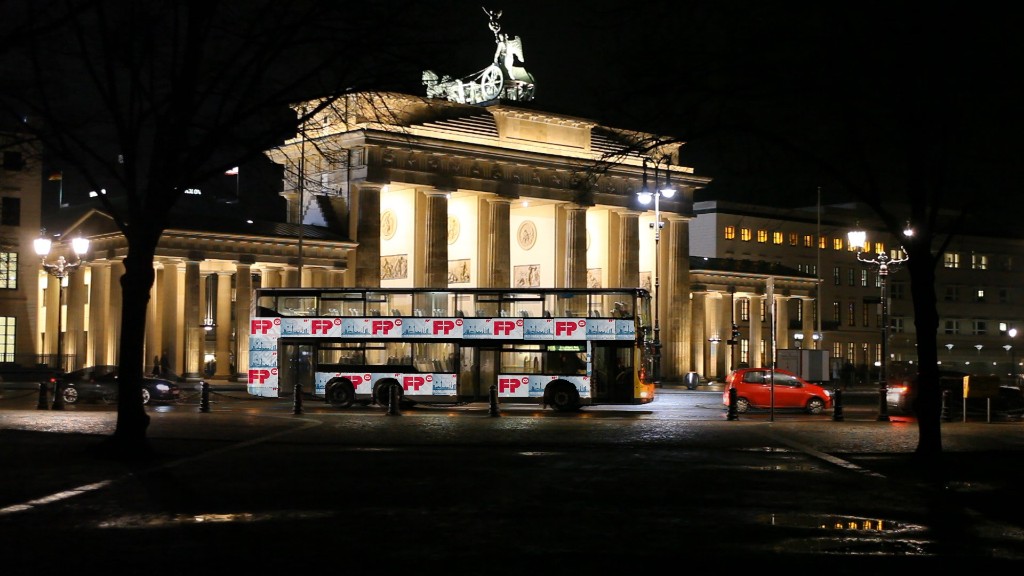 leuchtendes Brandenburger Tor mit gestaltetem BVG Bus